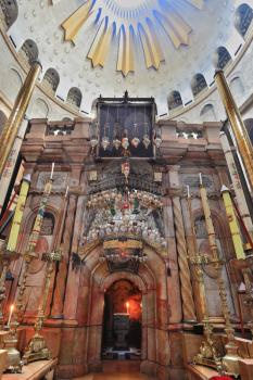 Church of the Holy Sepulcher in Jerusalem. Beautifully decorated with pink marble entrance Edicule, where the candle burns. The huge white dome of a ceiling is shined with the sun. The picture was tak