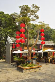 The tree decorated by garlands of red lanterns in the Chinese style