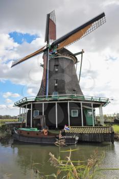 The village- museum in Holland. A picturesque windmill and the channel 