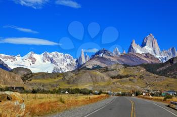 Famous rock Fitz Roy peaks in the Andes. Excellent highway in El Chalten.  Magnificent panorama of snow-capped mountains in Patagonia 