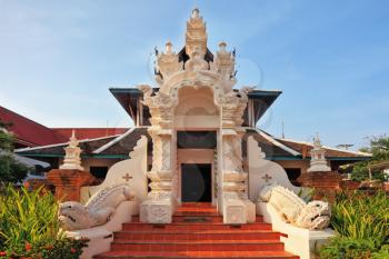 Magnificently decorated entrance to the Thai temple. At bright orange steps the footwear of pilgrims is left