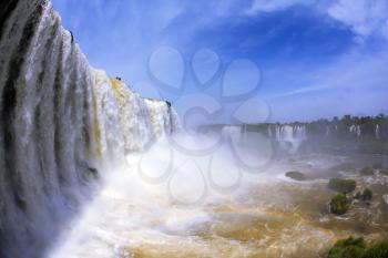 The most high-water waterfall in the world - Iguazu. White whipped foam of water and a thin mist over the water. The picture is taken by lens Fisheye