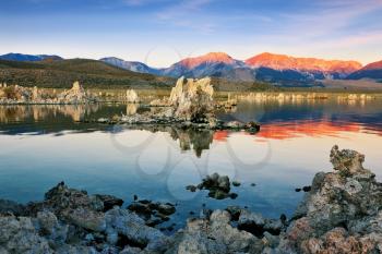 The magic of Mono Lake. Outliers - calcareous tufa formation  on the smooth water of the lake. Orange sunset