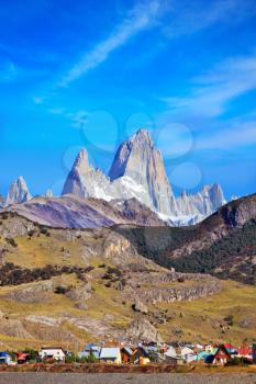 Famous rock Fitz Roy peaks in the Andes. Magnificent panorama of snow-capped mountains in Patagonia. At the foot of the mountains is a small tourist village of El Chalten