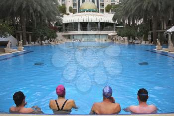  Group of fine sportsmen on training in pool of magnificent hotel