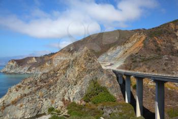 Huge viaduct on mountain road on Pacific coast USA. Bright serene autumn day