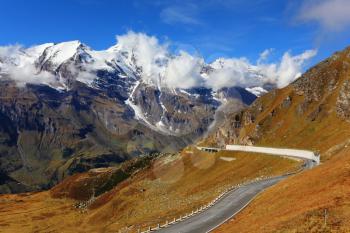Famous picturesque views of the road in Austrian Alps - Grossglocknershtrasse. Ideal highway winds high in the mountains. The highest mountain peaks covered with fresh snow