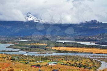 Patagonia. The picturesque valley is crossed by a winding river. On the horizon - snow-capped mountains