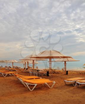 Winter in the Dead Sea. Beach tents and empty beach loungers