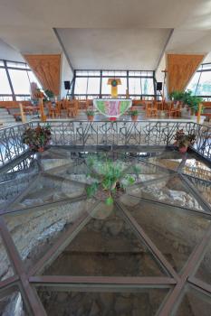 The interior of a modern church on the Sea of ​​Galilee. After a magnificent glass floor you can see the walls of ancient buildings