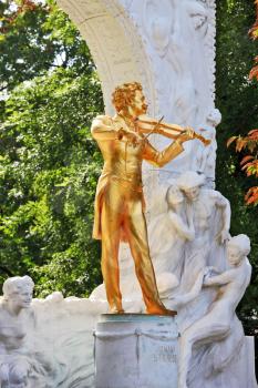 Waltz King plays. Gorgeous gilded statue of Johann Strauss with violin in Vienna park