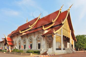 Gold-plated entrance to a Buddhist temple in northern Thailand. The roof of the temple - red with gold edge