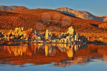 Blazing orange sunset at Mono Lake.  Yosemite National Park, USA. Outliers -  bizarre calcareous tufa formation  reflected in the mirrored surface of the water