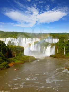 Waterfalls and incredible forms clouds. Black Andean condors fly over the foamy waterfalls of Iguazu. Brazil