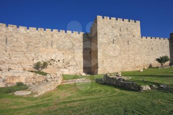 Wonderful green lawn.  Defensive wall of the ancient holy Jerusalem, lit by the bright sun