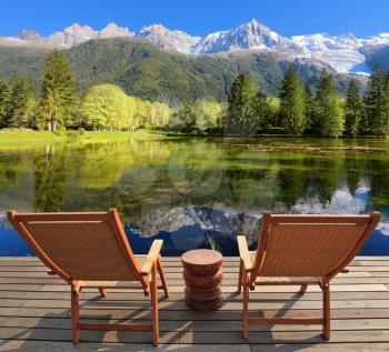 Comfortable lounge chairs on wooden platform for rest and observation. City park in the Alpine resort of Chamonix