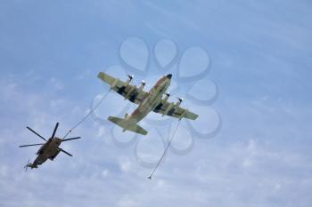 Refuelling in air is made with the plane and  helicopter on celebratory parade 