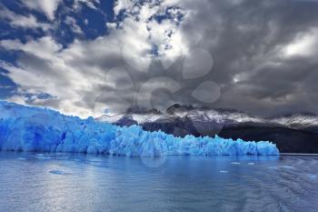  The clouds covered the sun cold. Grey glacier moves down the water of the lake. Chilean Patagonia. National Park Torres del Paine. Lake and Glacier Grey