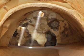 Famous Belfry Beit Guvrin caves in Israel. Giant halls regular shape with a hole in the roof. Through an opening in the ceiling of the cave inside the sun's rays penetrate