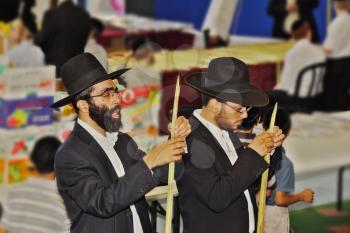 BNEI- BRAK, ISRAEL - SEPTEMBER 17, 2013: Traditional market before the holiday of Sukkot. Religious Jews in black hats and piles of carefully selected ritual plants