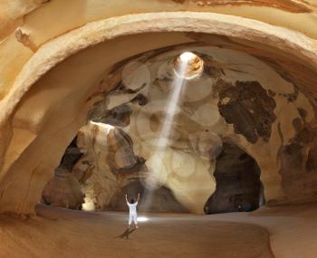  Yoga classes in the cave Beit Guvrin. Woman in white performs asana Sun salutation Israel