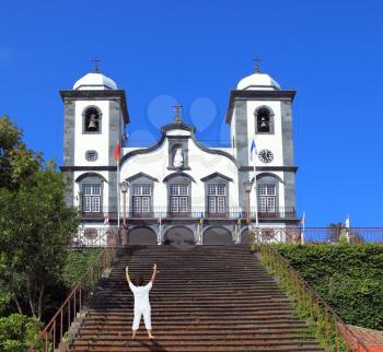 Middle-aged woman dressed in white doing yoga. Asana Blessing of the Sun.The wide staircase leads to the majestic white cathedral