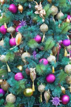 Magnificent fur-tree toys - pink and yellow glass spheres, peaks, decorative snowflakes and figures of fantastic heroes decorate a New Year tree. Happy Christmas!
