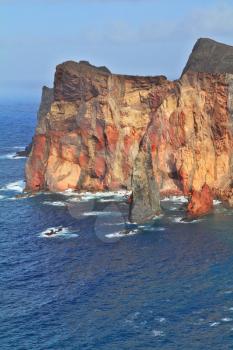 The eastern tip of the island of Madeira was bright sunset. Deep Bay with picturesque islands - rocks. Red rocks and blue sea