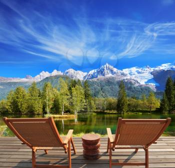City park in the Alpine resort. Comfortable lounge chairs on wooden platform for rest and observation