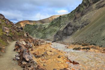 Steep mountain slopes, the path and the creek in the gorge. National Park Landmannalaugar in Iceland