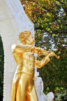 Park in Vienna.  Elegant gilded statue of Johann Strauss, playing the violin in white marble arch