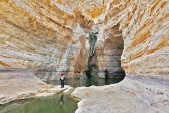 Beautiful gorge in the Negev desert. Ein Avdat Canyon, a female photographer taking pictures scenic landscape