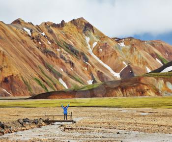 Pink and orange Mountains National Park Landmannalaugar in Iceland. Snow remained on the mountains last year. At the foot of the mountains is worth admiring woman -turist