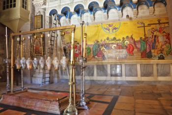The oldest Christian sanctuary - Stone of Unction. Temple of the Holy Sepulcher in Jerusalem. Fire burns in eight inextinguishable lamp