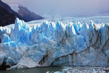  Huge Perito Moreno glacier in the Lake Argentino, surrounded by mountains.  Los Glaciares National Park in Patagonia. Sunny summer day