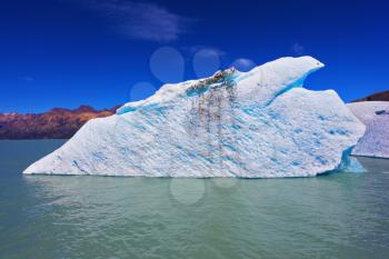  Excursion on the tourist boat on Lake Viedma. White and blue huge icebergs floating near the ship broadside. Ice and sun Patagonia, Argentina