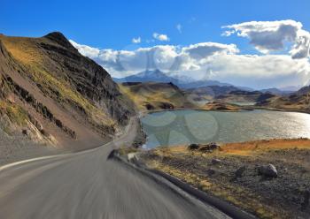 A trip at high speed. Dangerous driving in the national park Torres del Paine, Chile. A gravel road runs by the lakeside