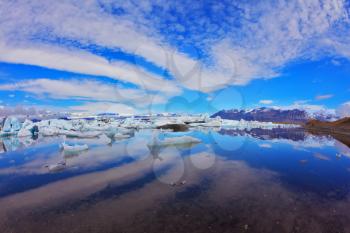 Cirrus clouds are beautifully reflected in the smooth water of the ocean lagoon. Jökulsárlón Glacial Lagoon in Iceland
