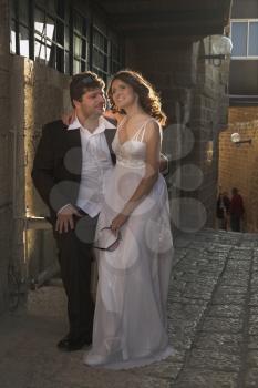 The beautiful, happy groom and the bride on prewedding walk in ancient to port.