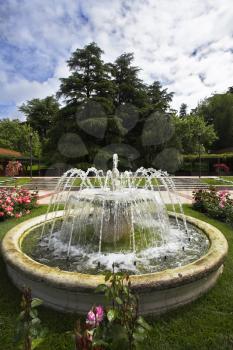 Charming round fountain in a garden of roses in Madrid