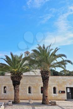 Courtyard of the ancient church on the Sea of Galilee is decorated with palm trees