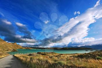 Azure Lake Pehoe and flying in the wind clouds. National Park Torres del Paine, Chile