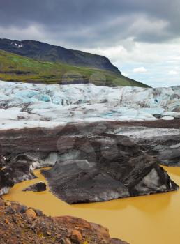 Skaftafell National Park. The southern part of the huge Vatnajokull glacier. Blue ice covered ground black volcanic ash