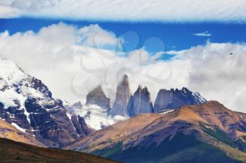 The primitive harmony of the national park Torres del Paine. Three of the famous rocks surrounded by picturesque clouds