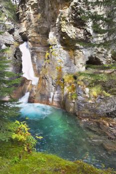 Magnificent falls with greenish water in mountains of Canada