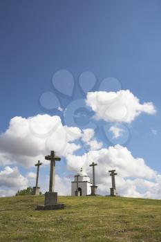 Glade with a chapel and memorable crosses on a background of the spring May sky with clouds