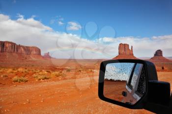 Monument Valley in the Navajo Indian Reservation. Arizona, USA. The unique red sandstone buttes are reflected in the car mirror