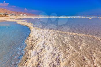 Vaporized salt form whimsical patterns on the water surface. Dead Sea off the coast of Israel
