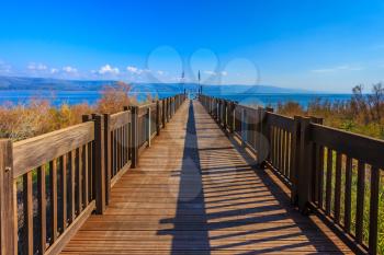 Wooden pier leading to the famous Lake Kinneret. Sunset on the Sea of Galilee