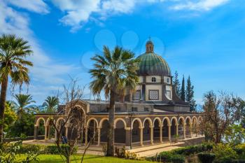 The dome of basilica is surrounded by a gallery with columns. Church Sermon on the Mount - Mount of Beatitudes. Subtle shade of palms and cypresses